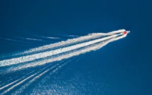 A boat moving fast on the water and creating a wake.